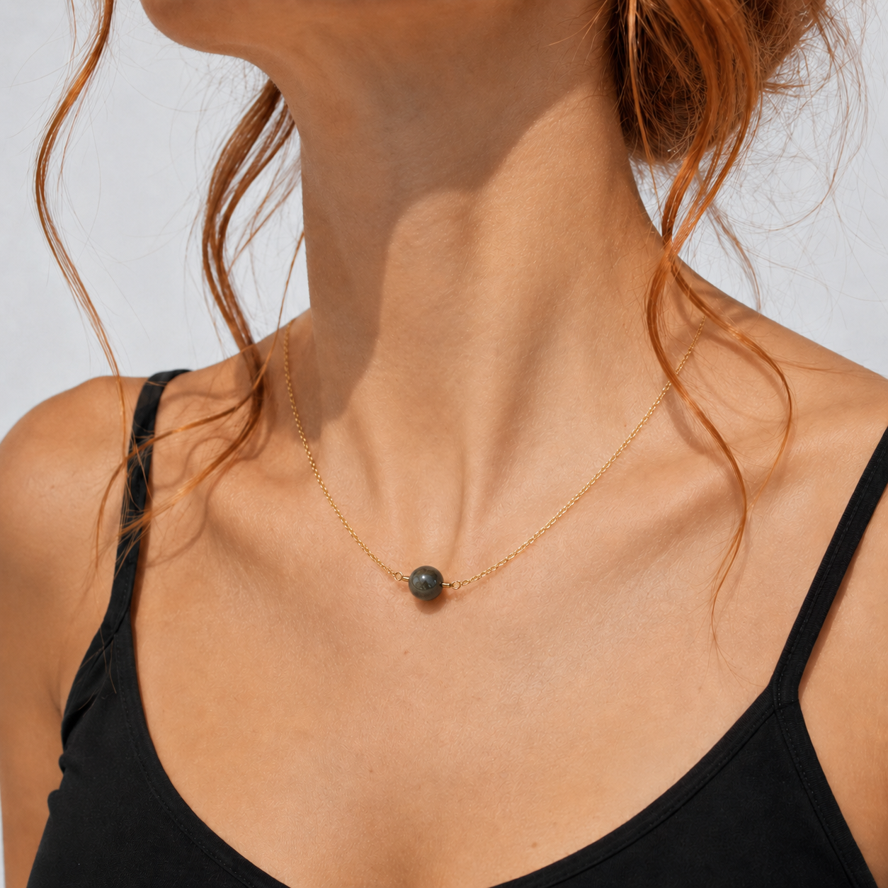 Primer plano del colgante de obsidiana dorada y su cadena