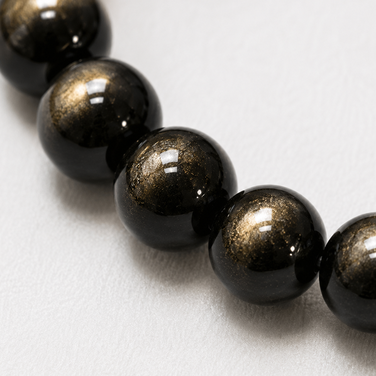 Detail of natural gold sheen obsidian beads