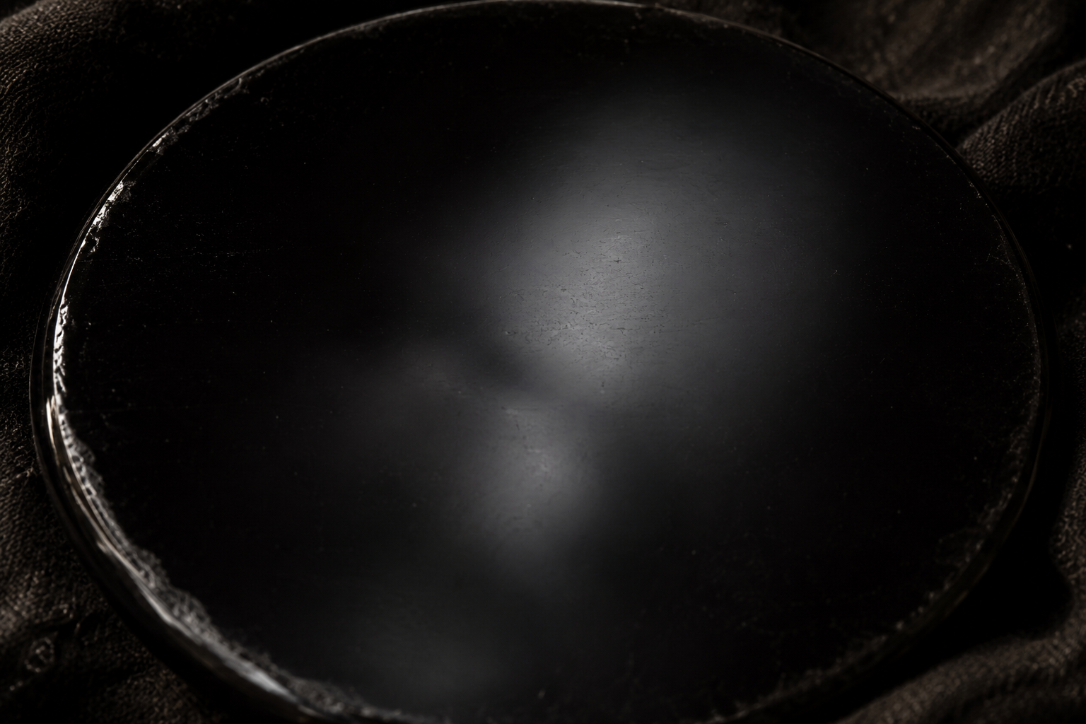 Gros plan sur la surface d'un miroir d'obsidienne au reflet flou