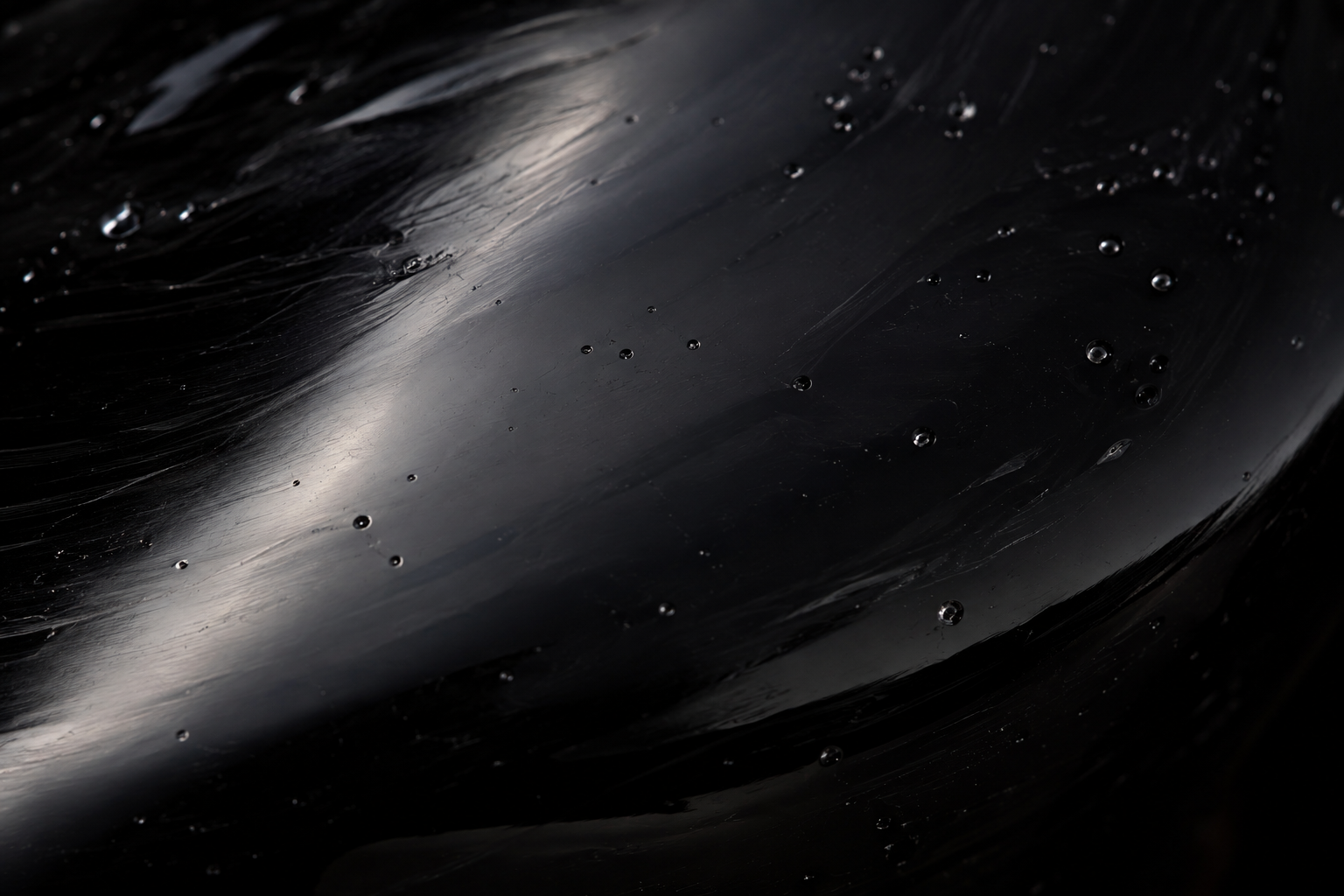 Macro de la surface vitreuse d'un miroir en obsidienne noire polie