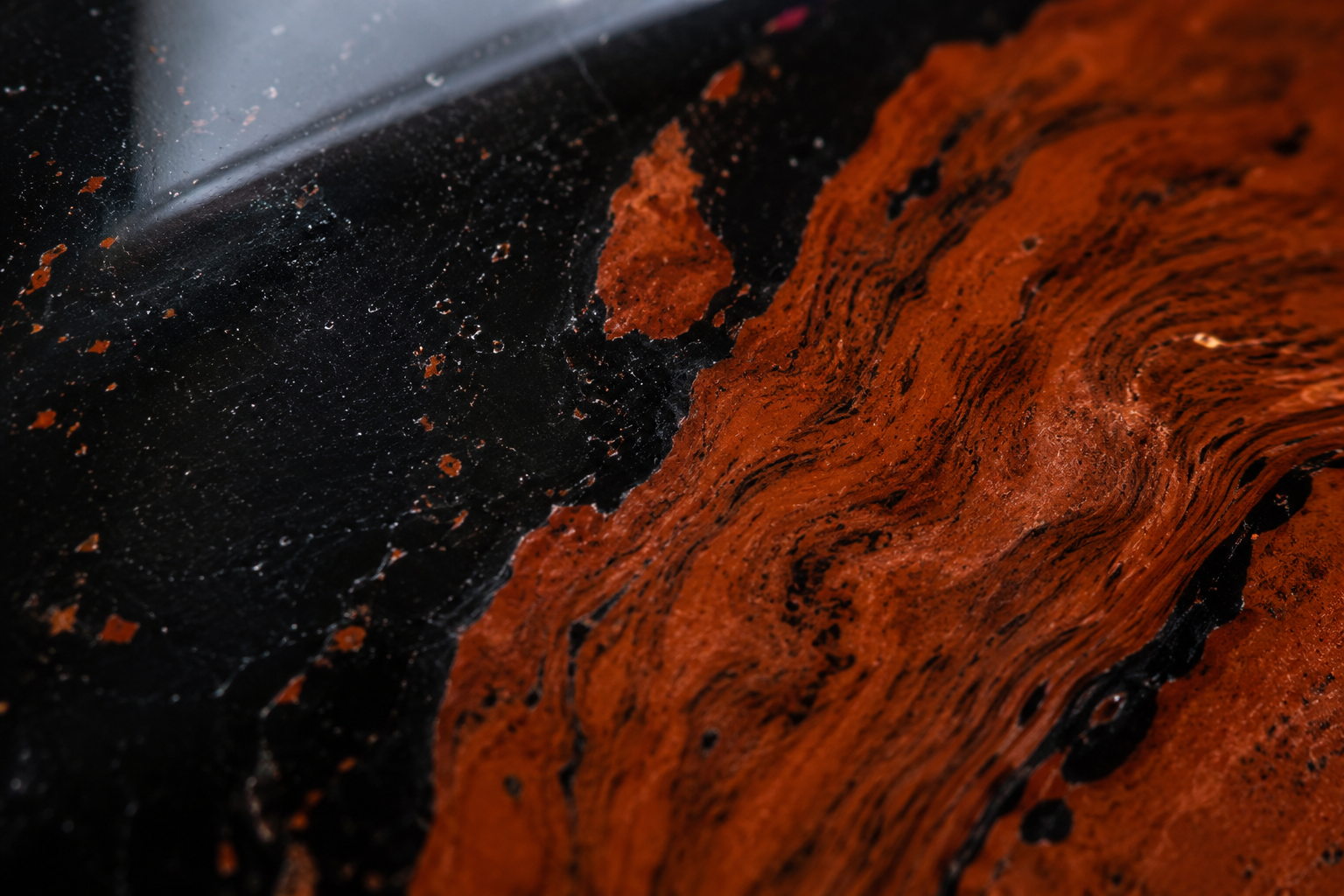 Macro des veines brun-rouge d'hématite dans une obsidienne acajou