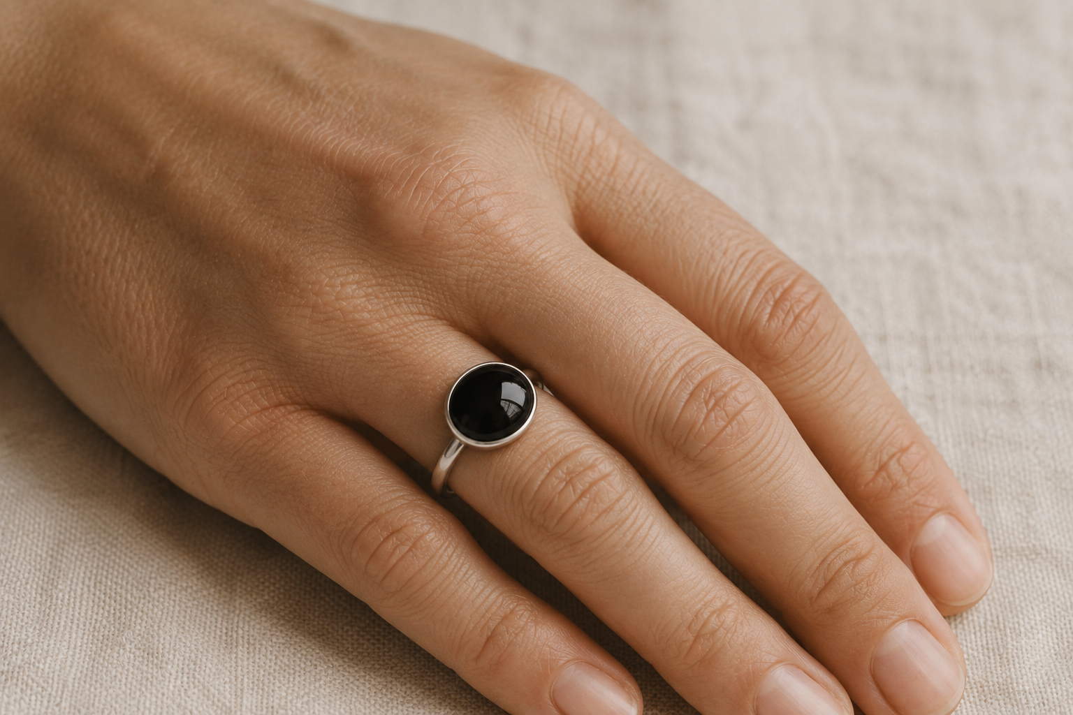 Black obsidian ring worn on a hand in natural light