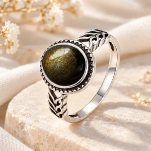 Bague en argent à anneau travaillé en épi tressé, cabochon rond d'obsidienne dorée