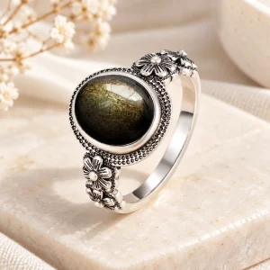 Bague en argent, cabochon d'obsidienne dorée avec fleurs placées sur les côtés