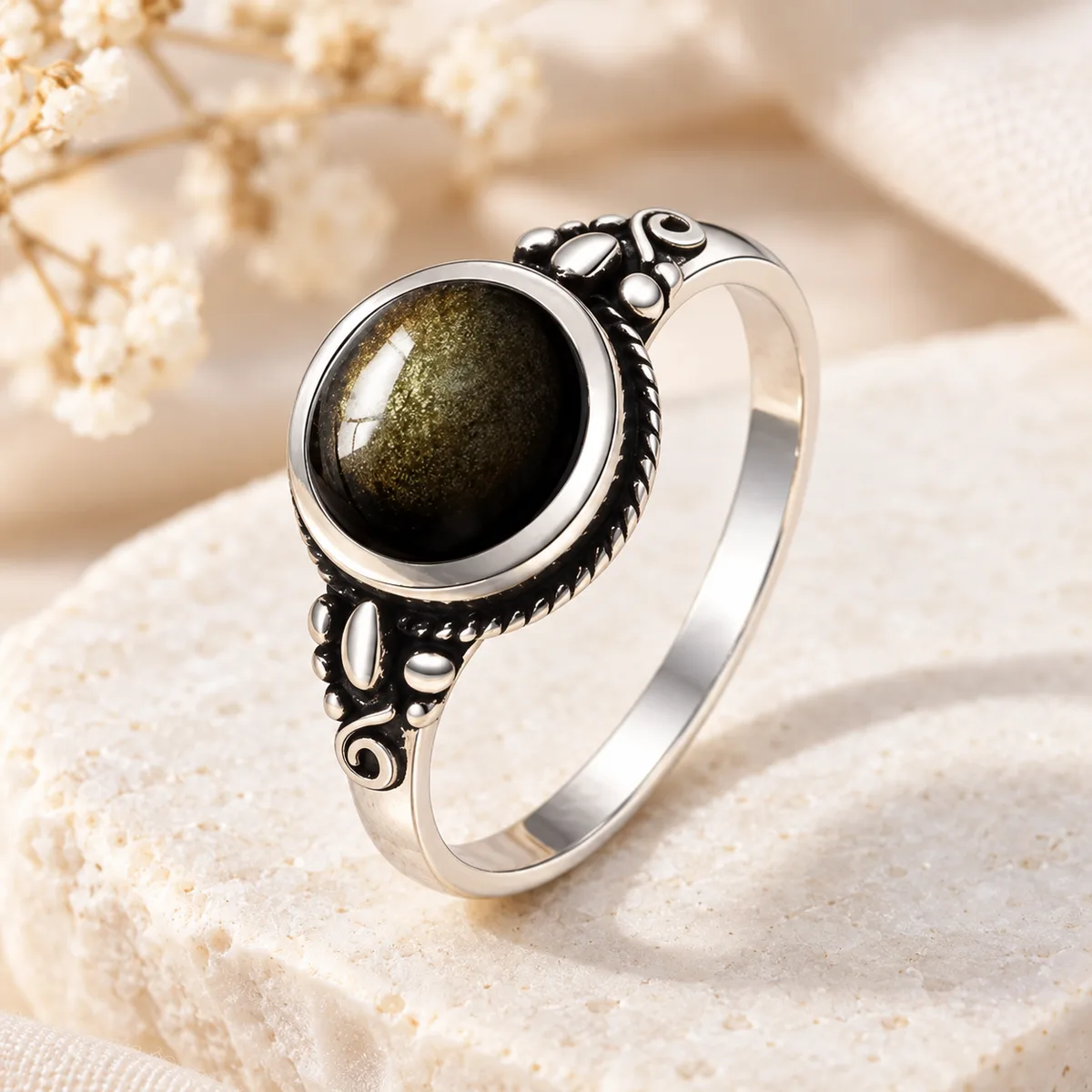 Bague argent obsidienne dorée à volutes Bague en argent à volutes, cabochon ovale d'obsidienne dorée serti clos