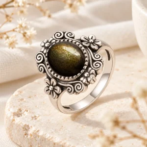 Bague en argent mêlant volutes et fleurs, cabochon ovale d'obsidienne dorée