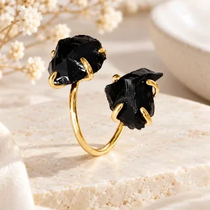 Bague dorée ouverte portant deux éclats d'obsidienne brute griffés aux extrémités