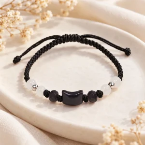 Bracelet cordon noir à nœud coulissant, plaquette d'obsidienne posée à plat