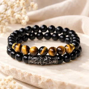 Duo de bracelets, un rang d'obsidienne et un rang où l'œil de tigre traverse le noir, barrette ciselée