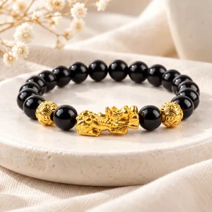 Bracelet Pixiu en métal doré sur un rang de perles d'obsidienne noire lisses