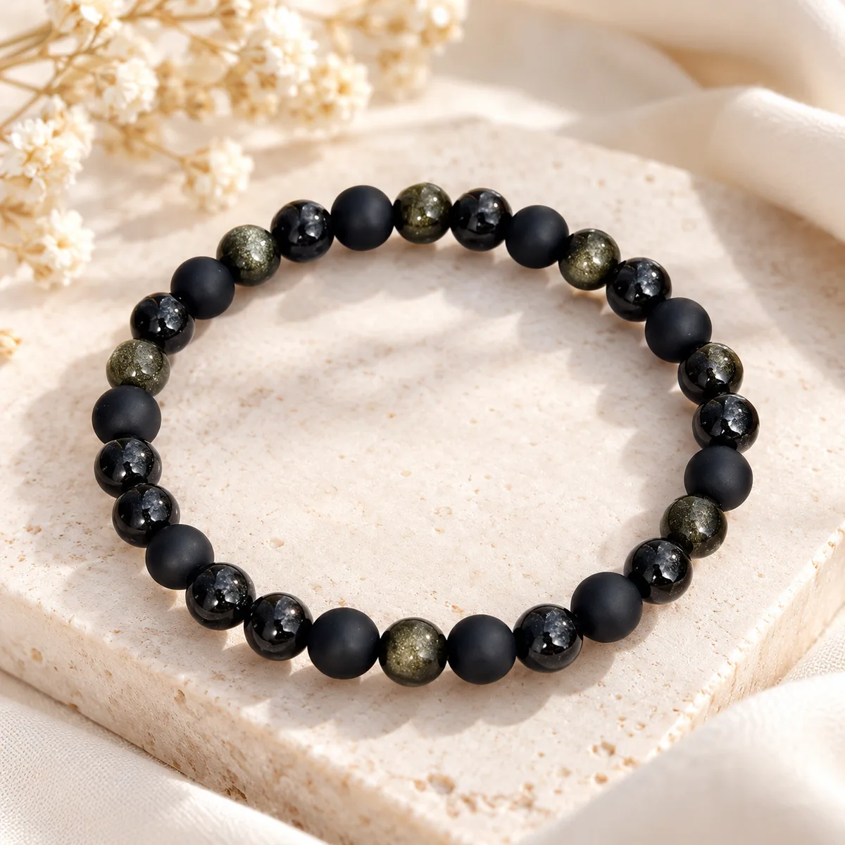 Bracelet trois obsidiennes Bracelet mêlant trois obsidiennes de 8 mm, mate, dorée et flocon de neige