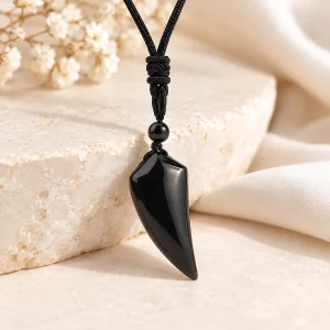 Pendentif croc d'obsidienne courbe, poli miroir, sur cordon noir