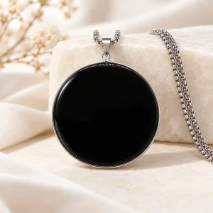 Pendentif disque rond d'obsidienne poli miroir, cerclé d'acier inoxydable, sur chaîne