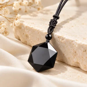 Pendentif en obsidienne taillée en polyèdre à vingt faces triangulaires, sur cordon noir