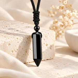 Pendentif en obsidienne taillée en prisme hexagonal terminé en pointe, sur cordon noir
