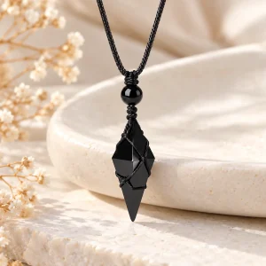 Pendentif en pointe d'obsidienne bipyramidale, tenue par un fil noir enroulé
