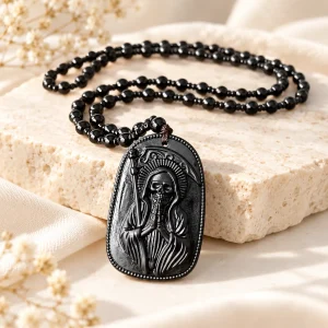 Pendentif en obsidienne, Santa Muerte sculptée en relief, sur chaîne de perles d'obsidienne