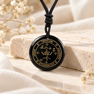 Pendentif disque d'obsidienne gravé d'un sceau et de ses inscriptions rehaussées d'or